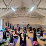yogis lying down with legs in the air